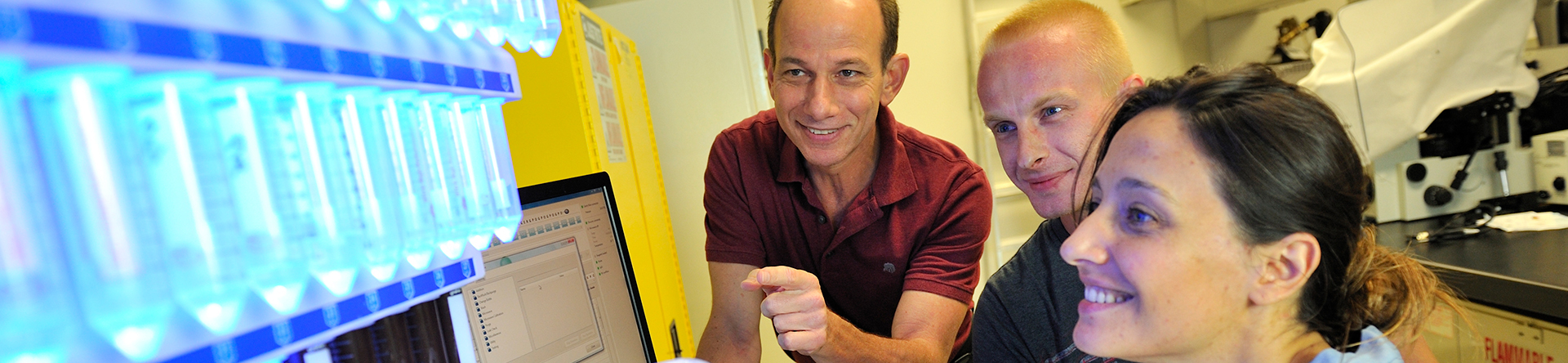 Male and female student in lab with male professor