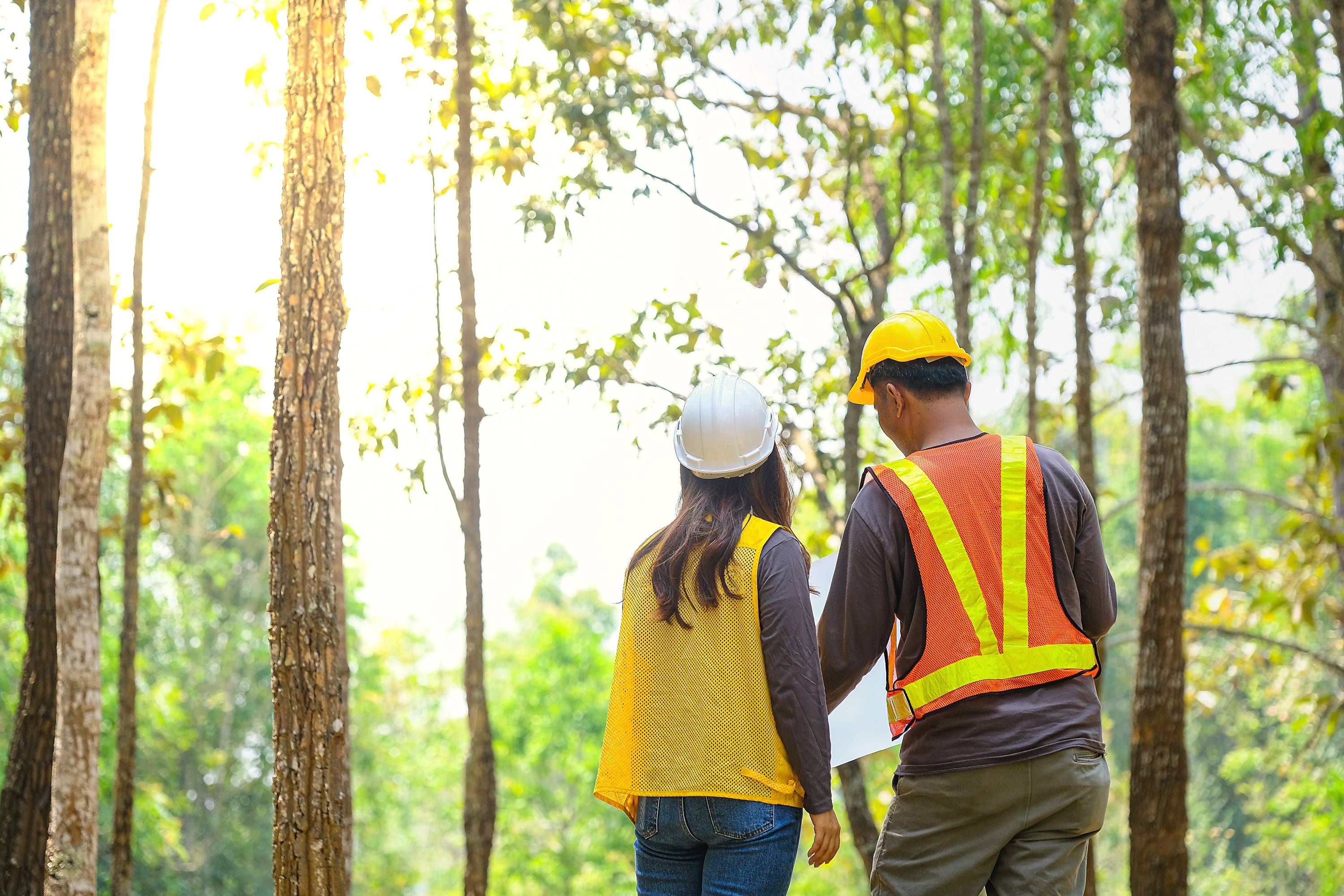 Two students with hard hats looking at plans