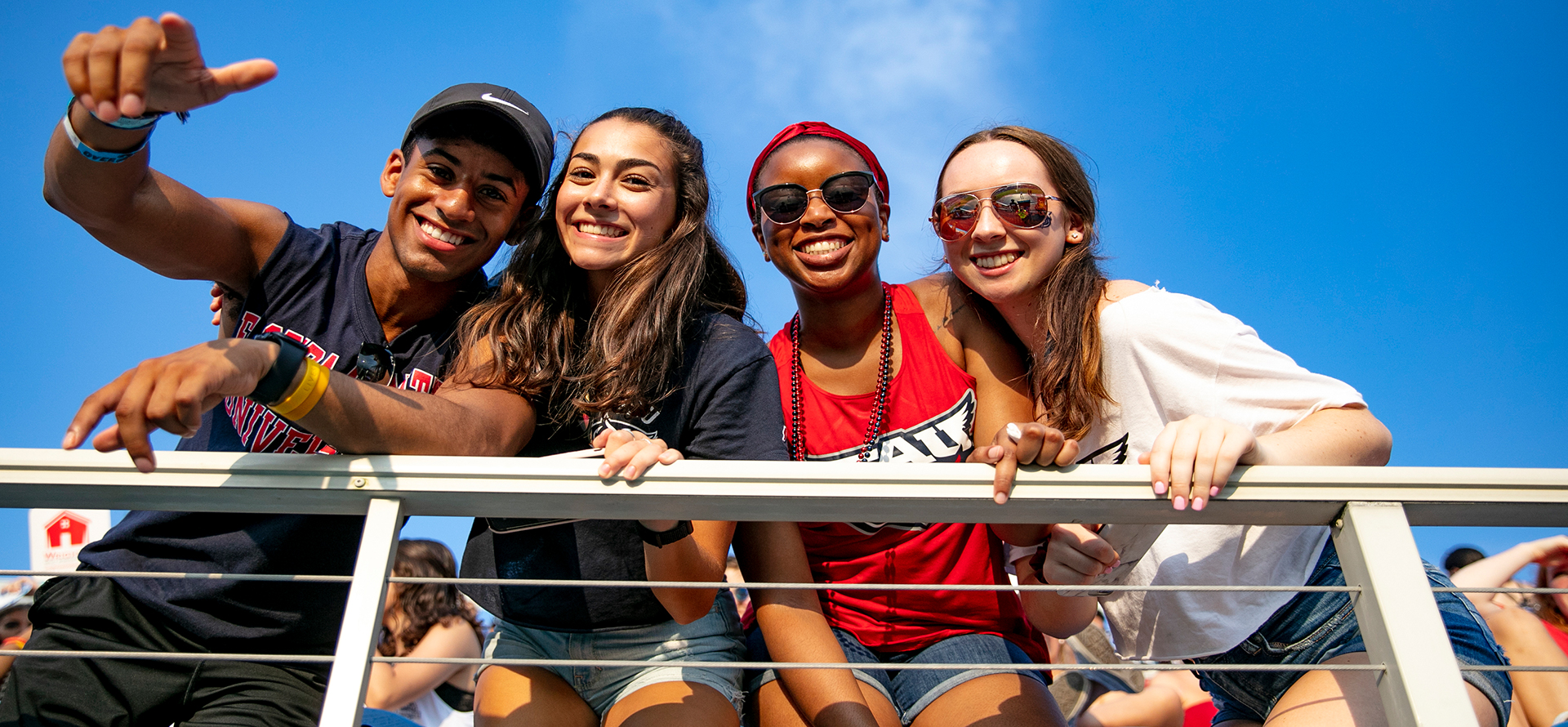 A group of diverse students smiling from the stadium