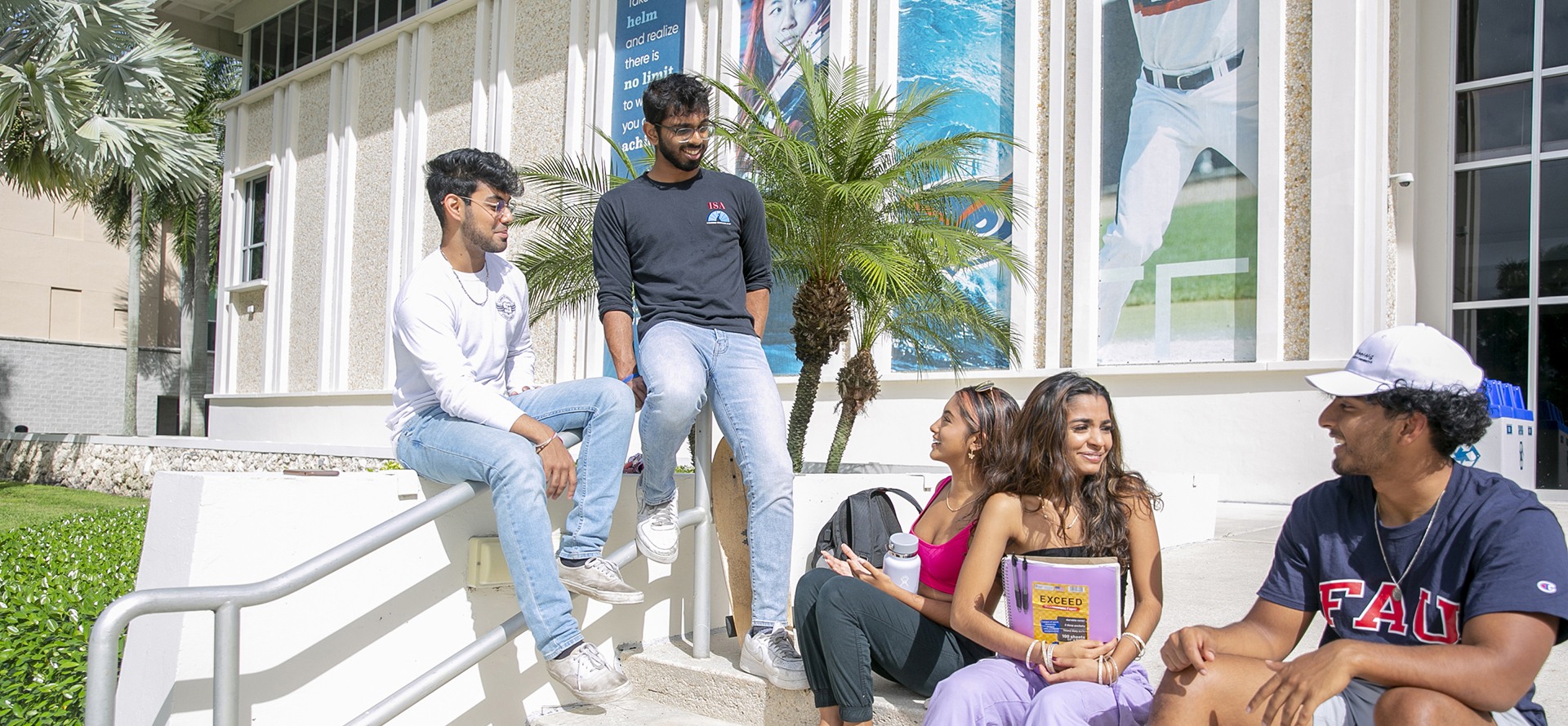 Students talking in a group in front of the FAU Administration building