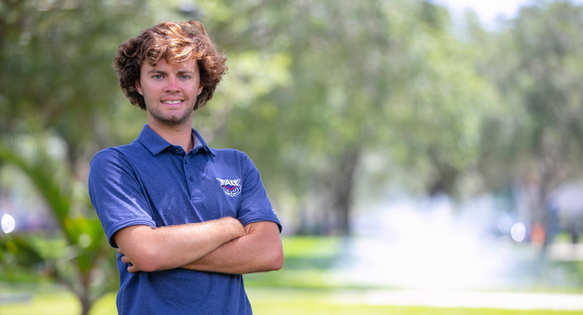 Student standing against a sunny background
