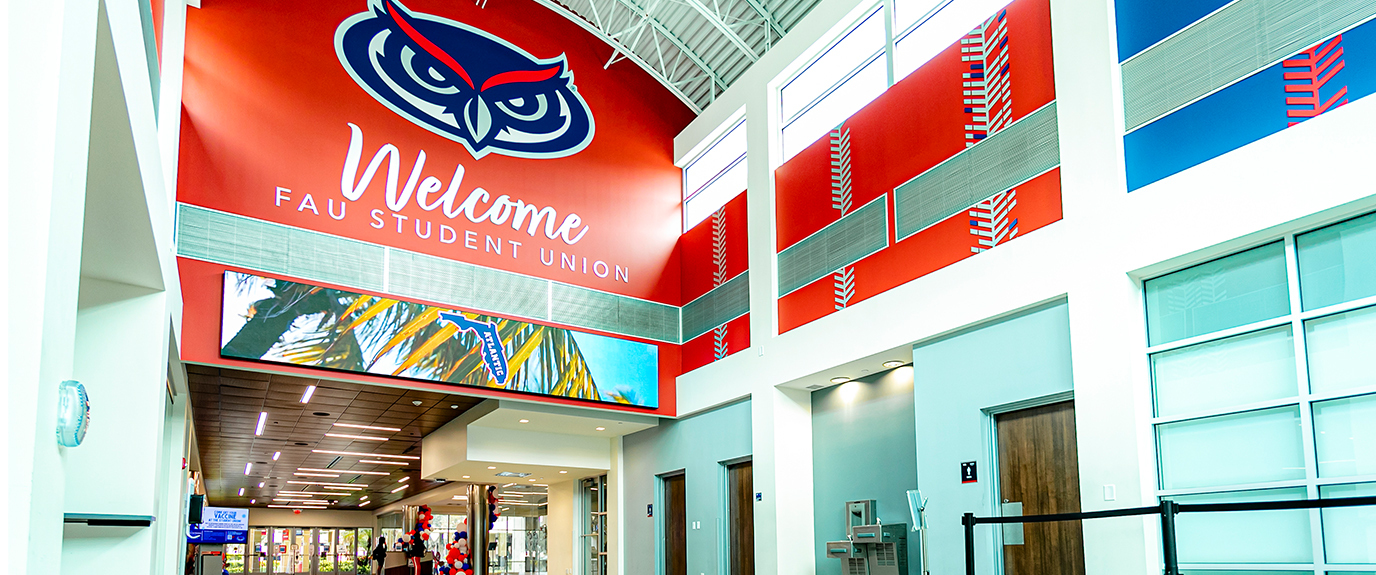 Digital rendering of the future FAU Student Union from an outside view which includes a fountain, seating areas, and students and trees