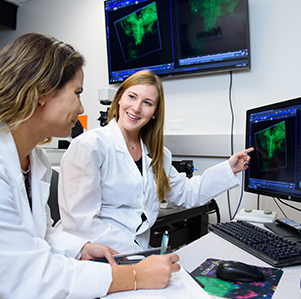 Two female students in a lab looking at a computer